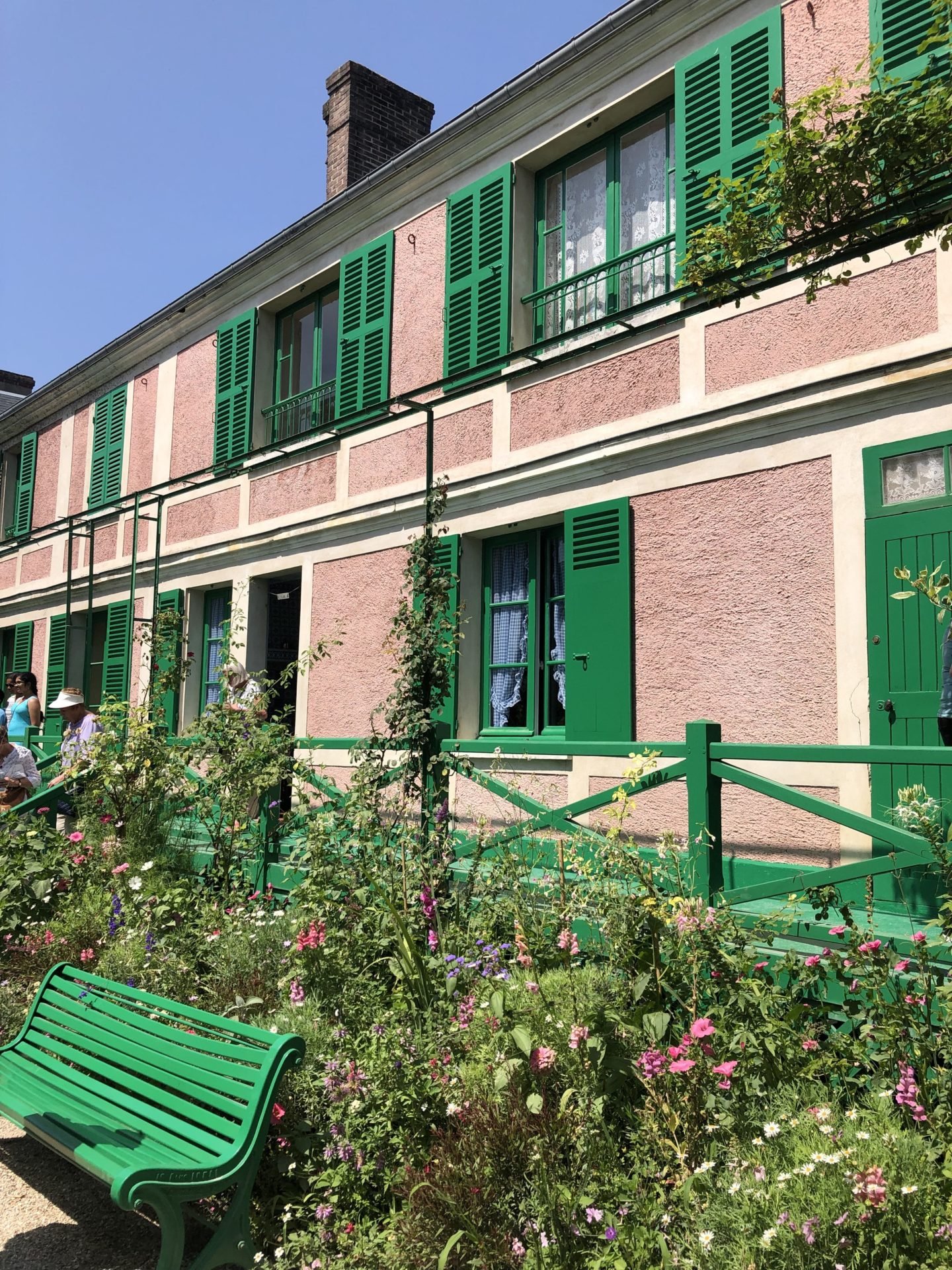 The Monet house in Giverny front veranda painted in pink and green