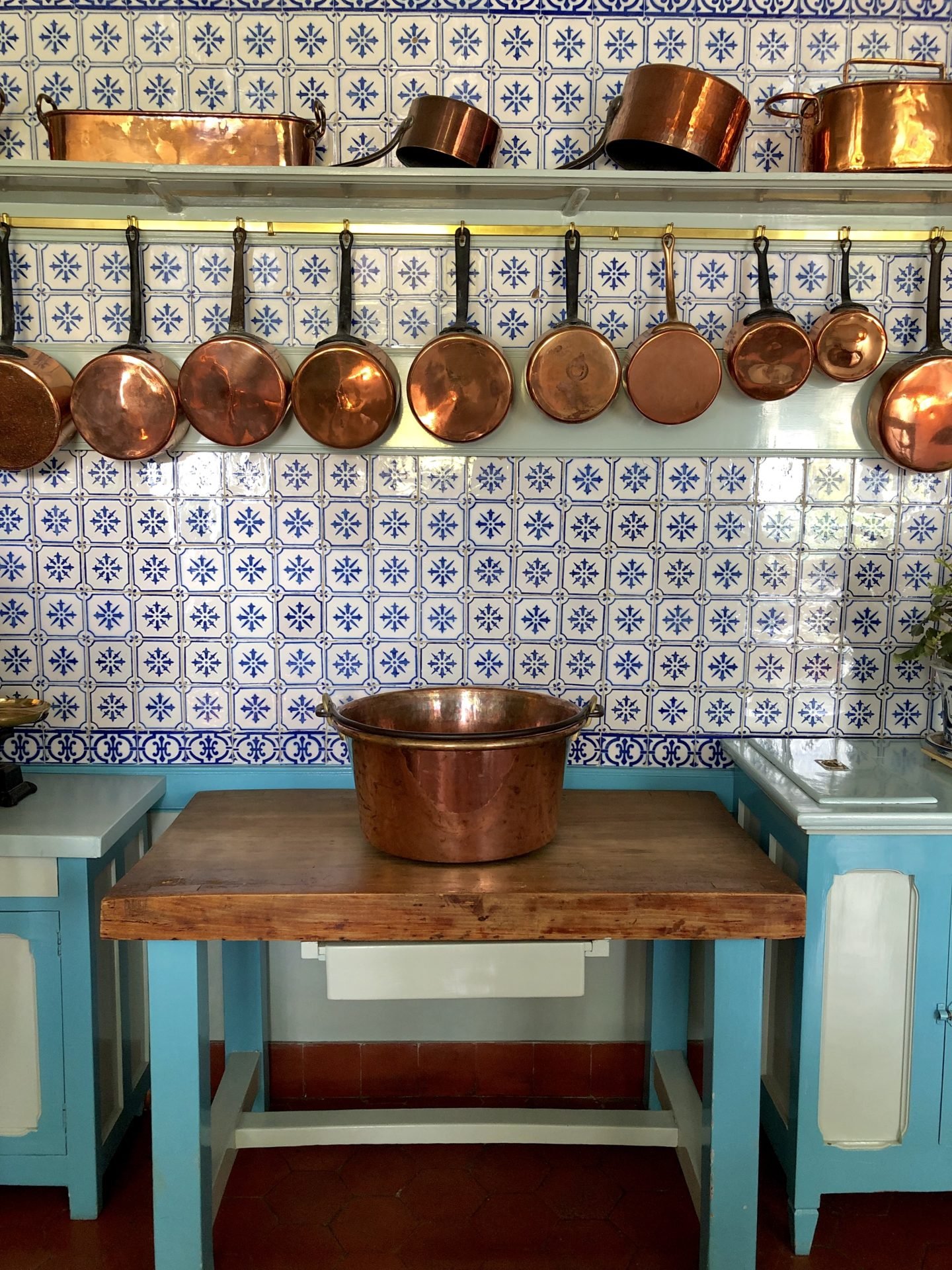The tiles on Claude Monets kitchen walls are from Rouen and the copper pots contrast  with the blue and white tiles.