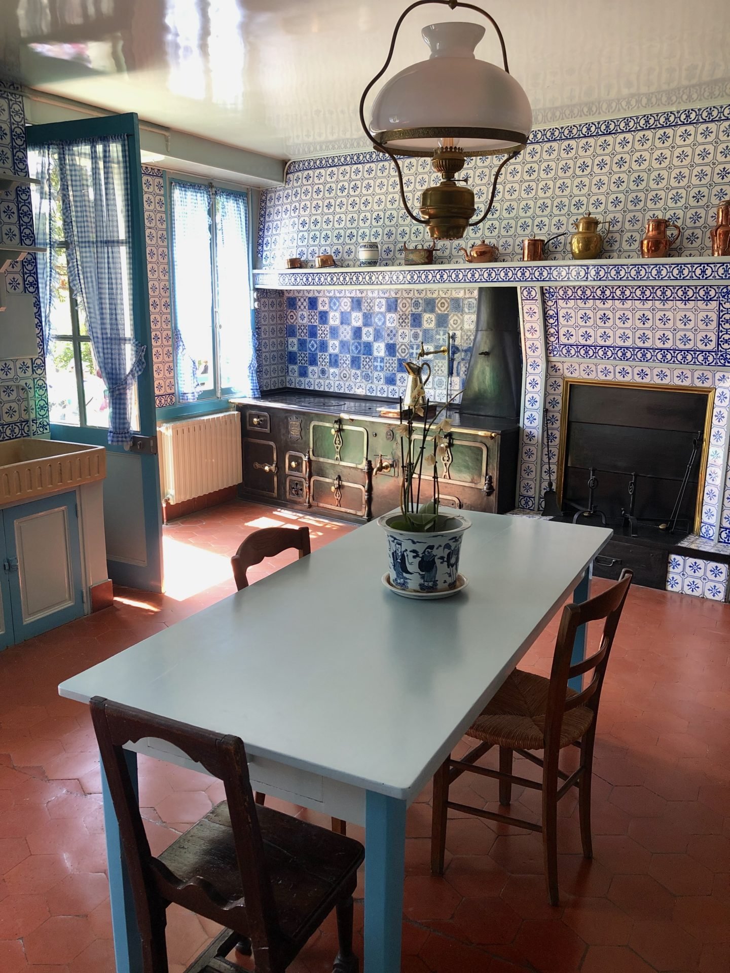 The Blue kitchen in the Monet House with tiles from Rouen. A huge oven sits in the corner.