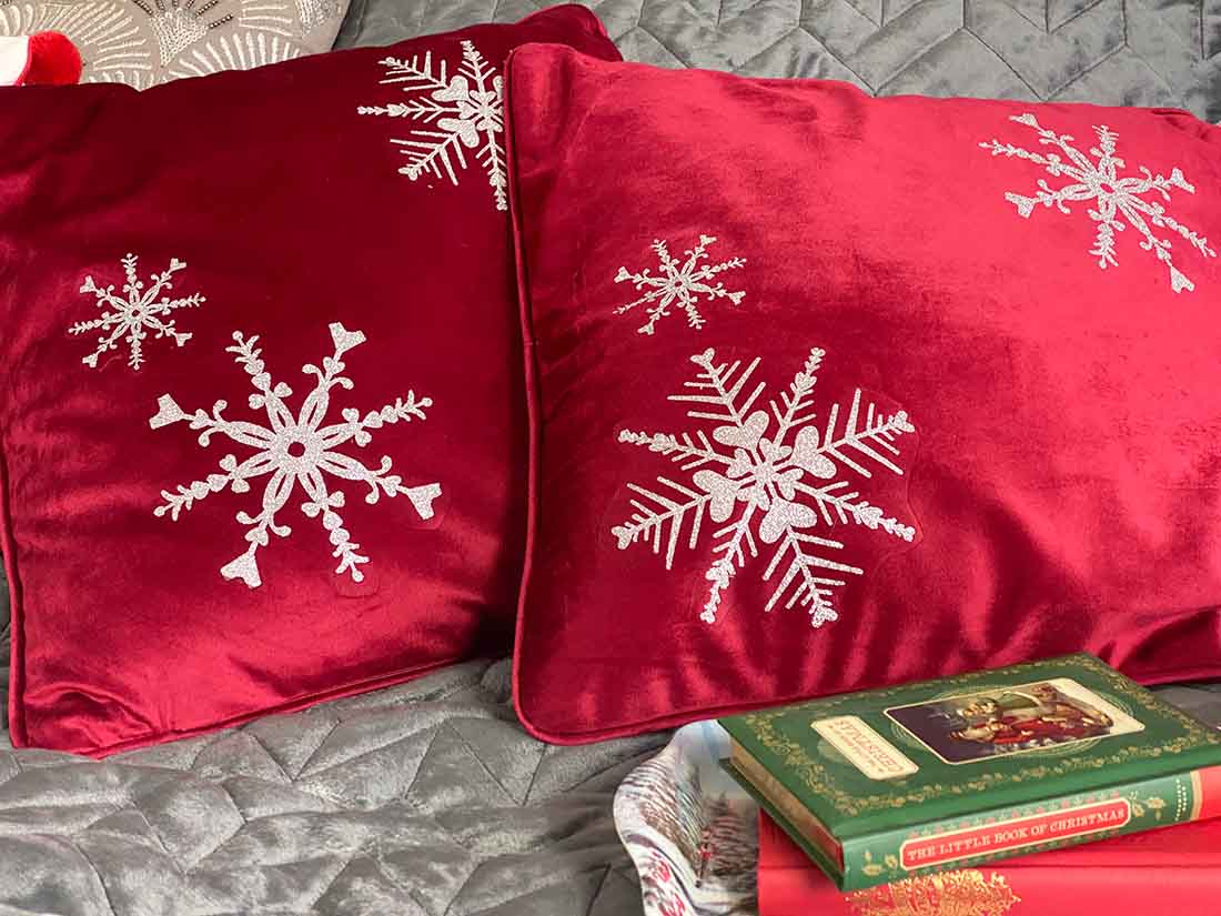 Free Heart Snowflake PNG on red velvet cushions with silver glitter vinyl snowflakes on a Christmas styled bed. Free heart snowflake cut file used