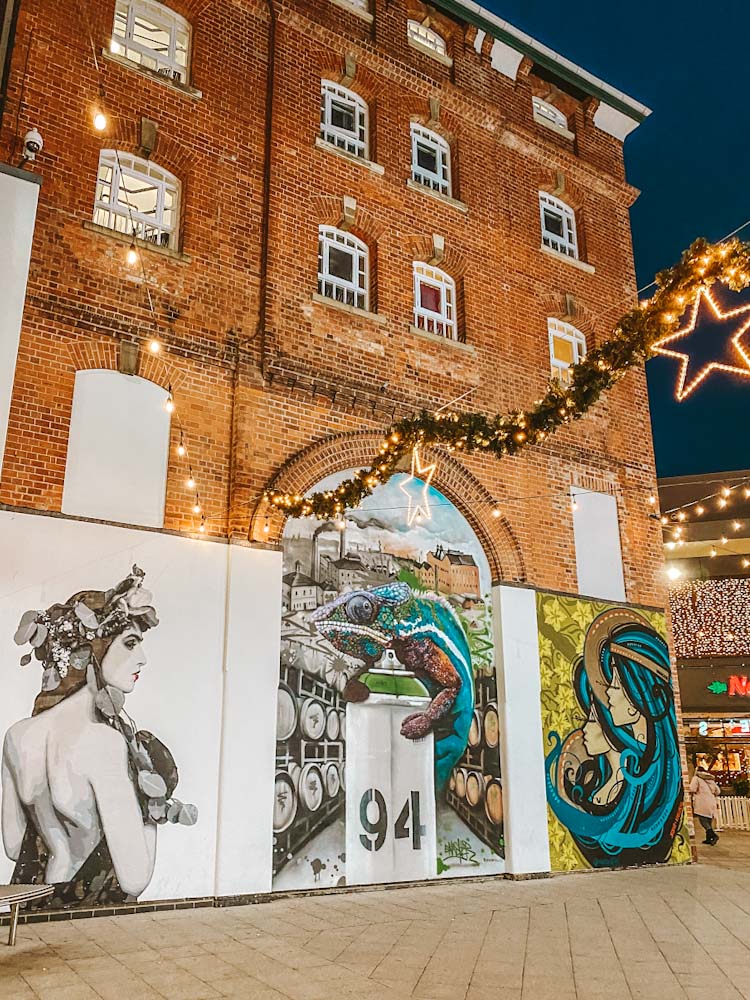 Christmas lights switch on at the Brewery Quarter in Cheltenham next to street art 