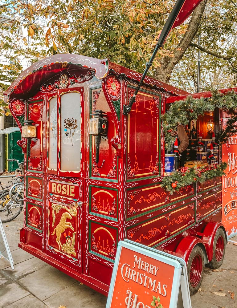 Traditional Christmas market at the Promenade in Cheltenham . Stunning painted Rosie’s caravan serving hot chocolate with Baileys.