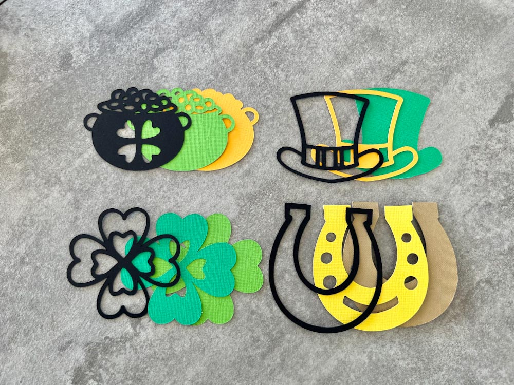 Free mini layered St. Patrick’s day SVGs, Shamrock, Leprechaun hat, Pot of gold and a horseshoe charm. 3layer SVGs
