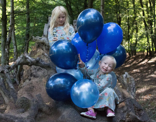 Children with Blue balloons for a gender reveal party